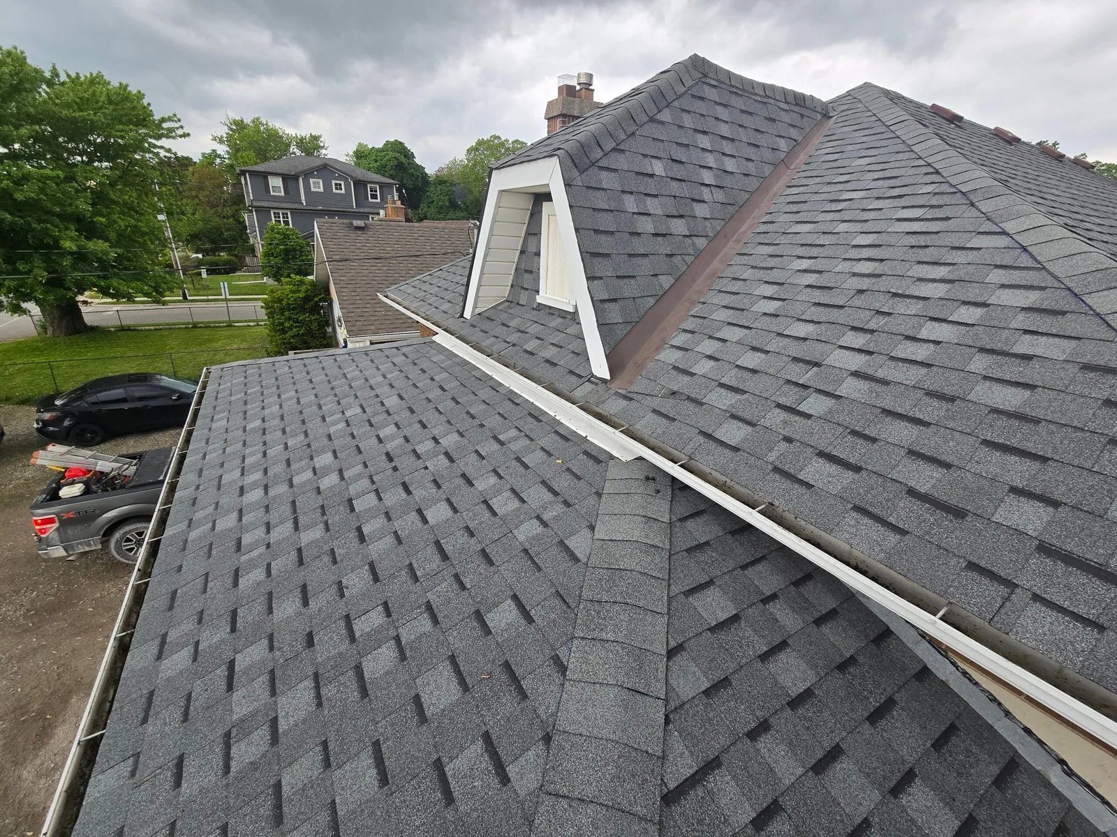 Completed grey tiled pitched roof with intersecting slopes