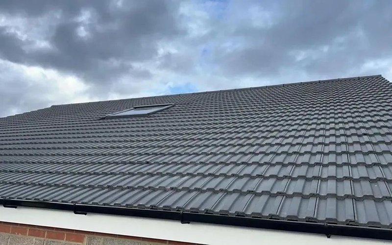 Completed dark slate roof on a terraced residential building