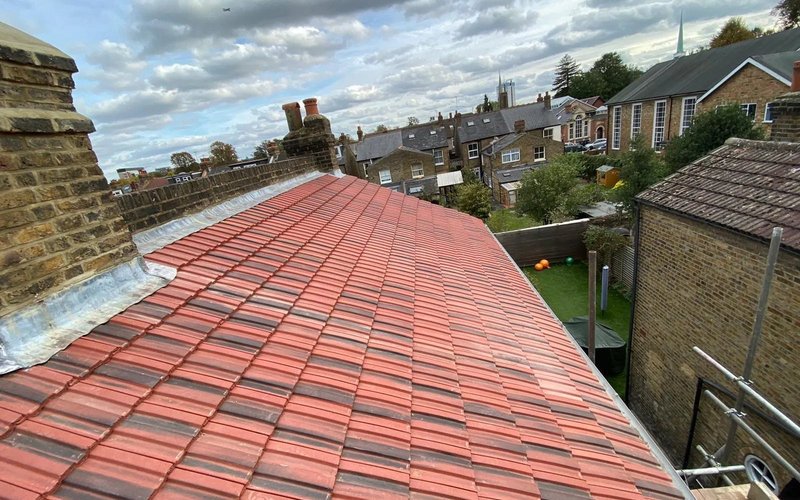 Red tiled pitched roof with neighbouring houses in the background