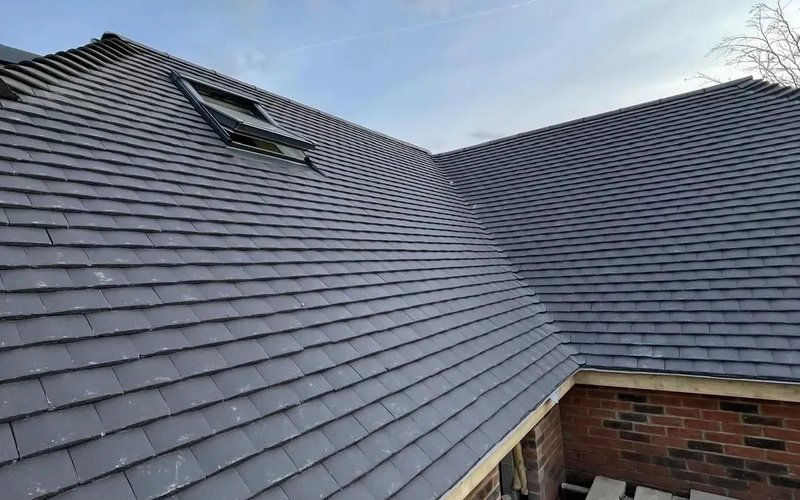Grey tiled pitched roof with skylight and adjoining roof valleys