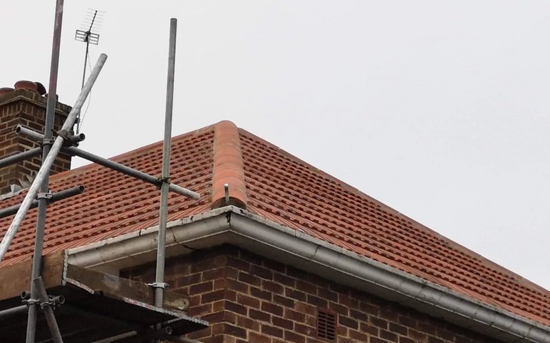 Brown pitched tiled roof with scaffolding alongside the property