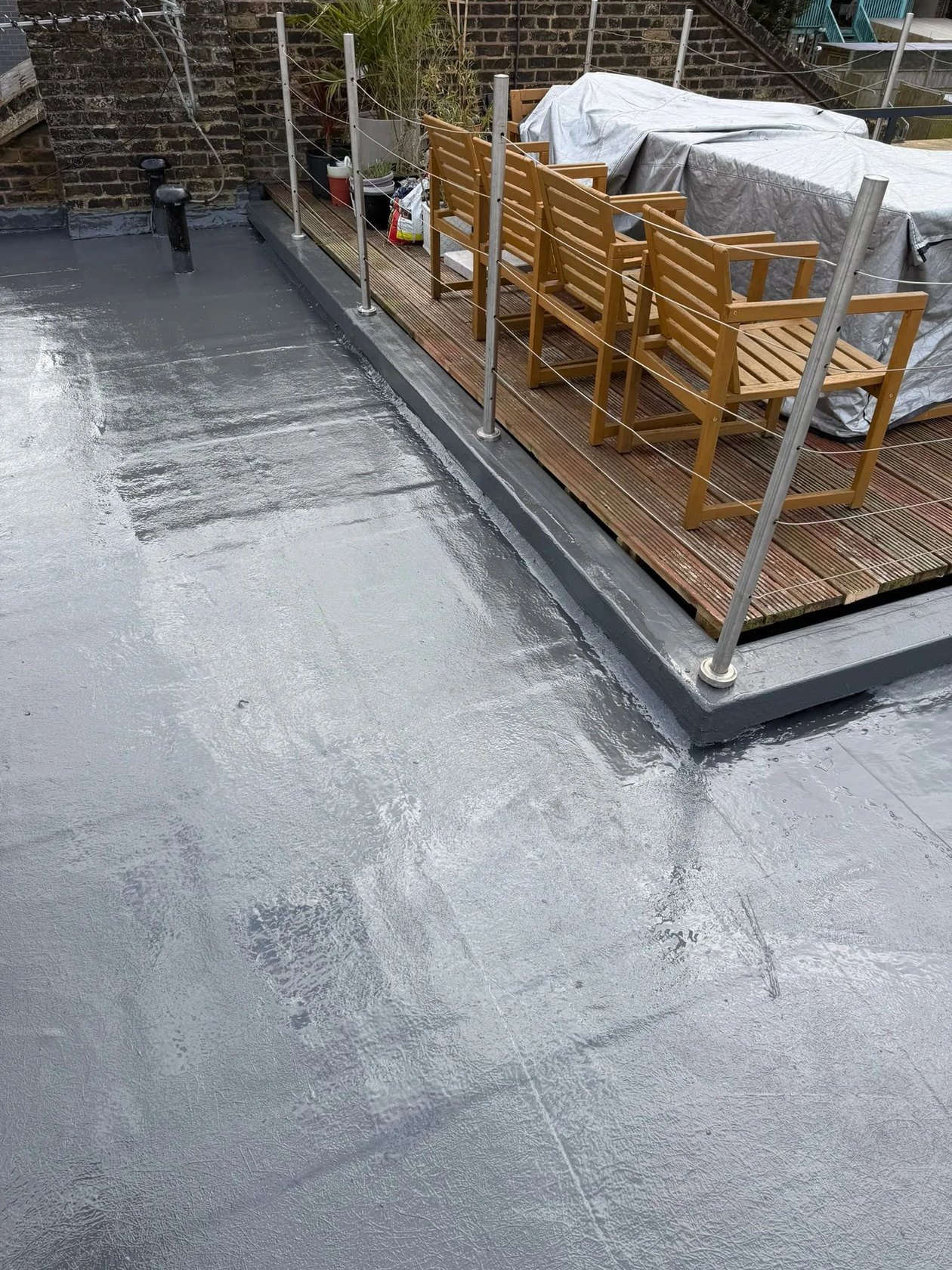 Flat roof waterproofing membrane next to timber decking
