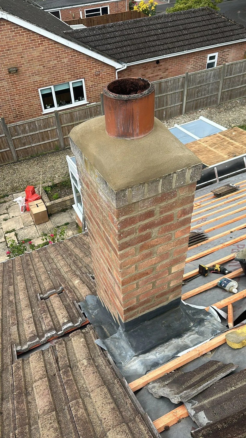 Roof repair work beside a chimney and scaffolding