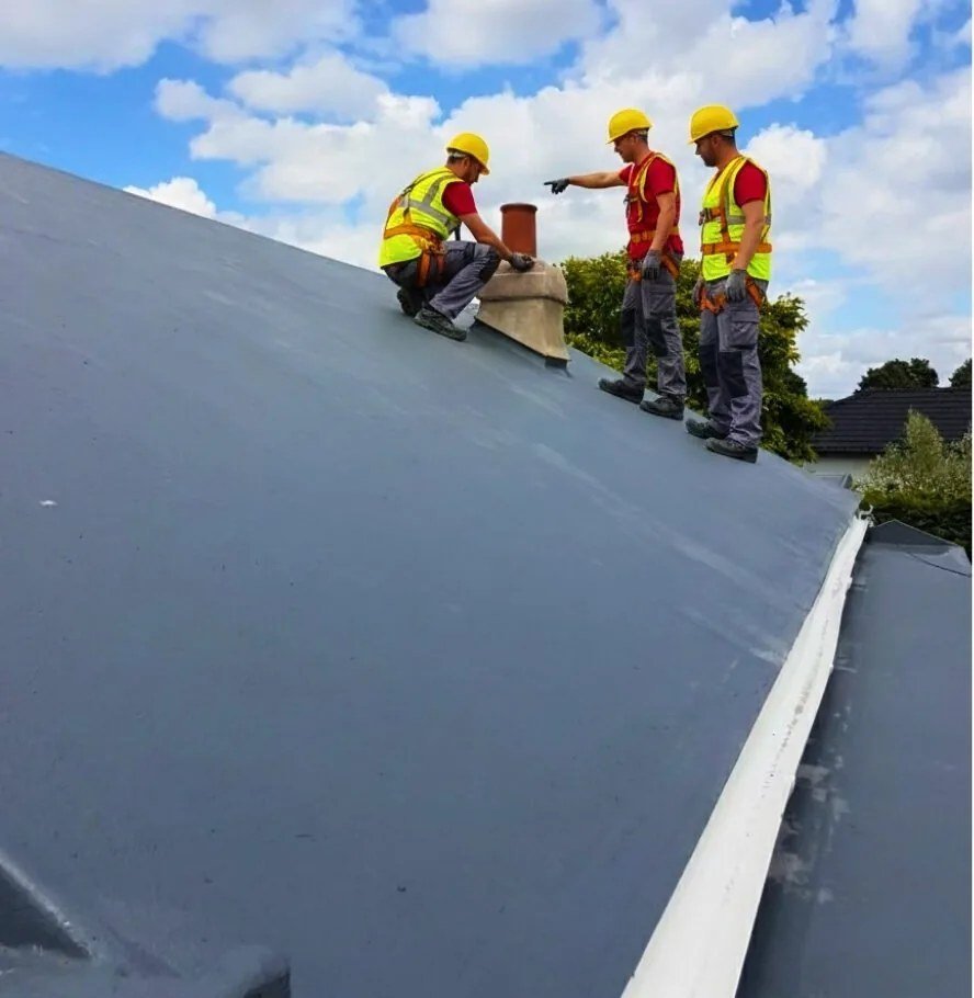 Roofers working with a flat roof waterproofing membrane